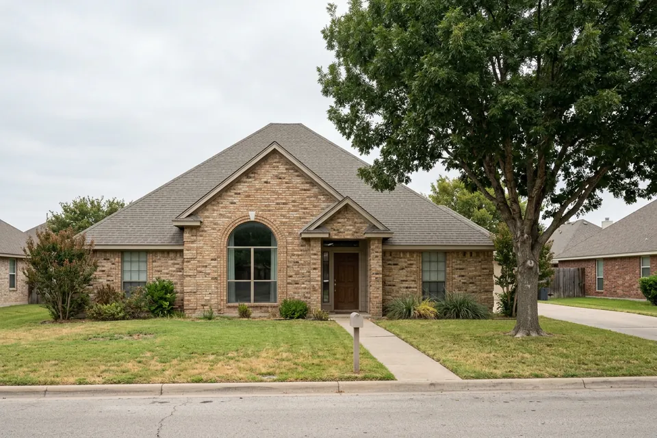 Illustration of a 1990s tan brick house with a tall roof