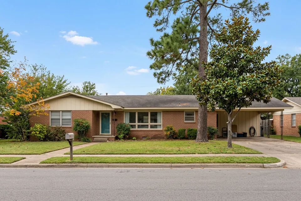 Illustration of a 1960s brick ranch house with a carport