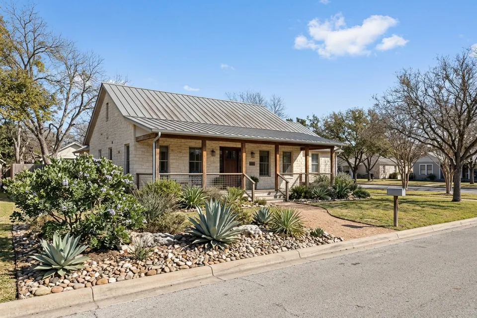 Illustration of a limestone ranch house with a metal roof