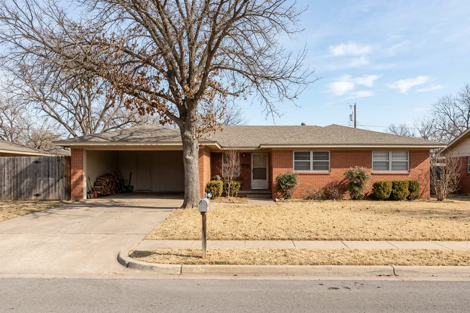 Illustration of a 1960s red brick ranch house with a carport