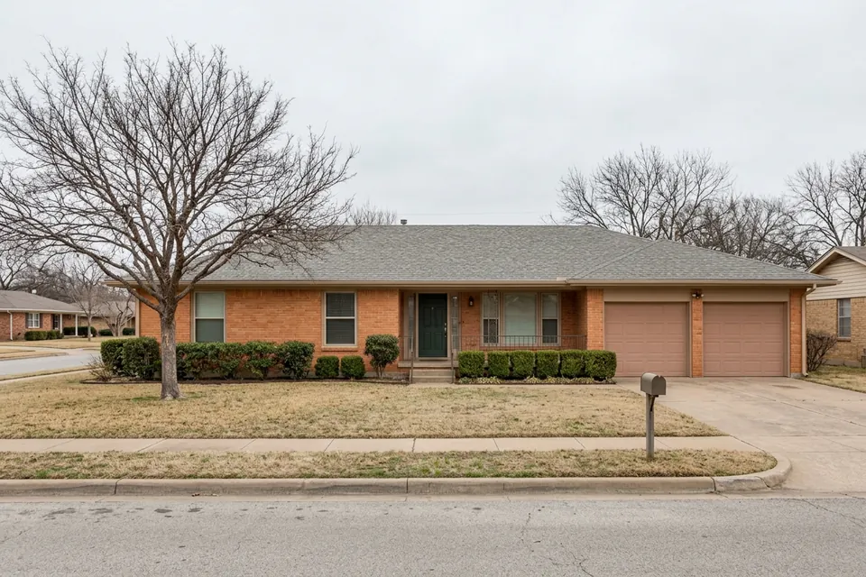 Illustration of a 1970s brick ranch house with a two-car garage